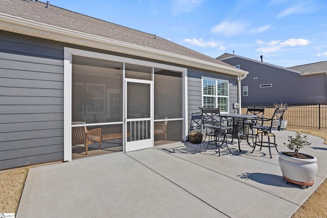 view of patio / terrace with a sunroom, fence, and outdoor dining space