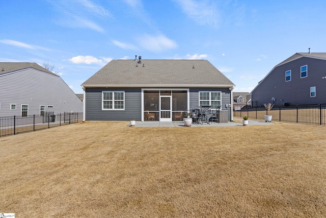 rear view of house with a patio, a fenced backyard, a shingled roof, a sunroom, and a lawn