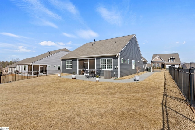 rear view of property featuring a yard, a fenced backyard, central AC unit, and a patio