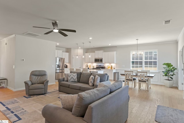 living room featuring light wood-type flooring, visible vents, recessed lighting, and ceiling fan with notable chandelier