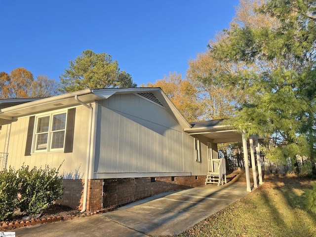 view of property exterior featuring an attached carport, crawl space, and driveway