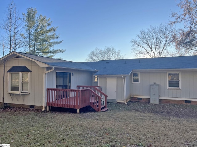 back of property with crawl space, roof with shingles, a lawn, and a wooden deck