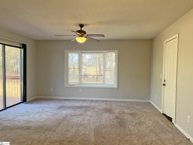 unfurnished room featuring a textured ceiling, ceiling fan, carpet flooring, and baseboards