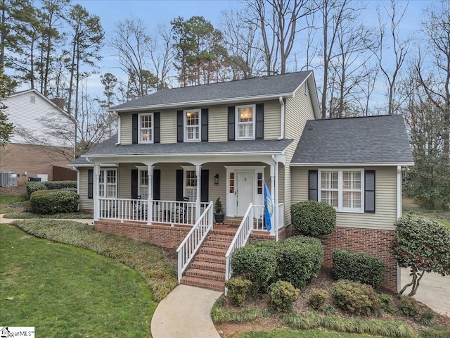 view of front of home with a porch, brick siding, stairs, and roof with shingles