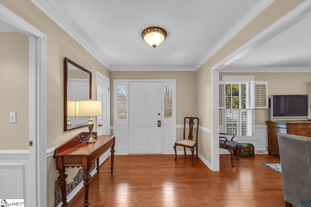 entrance foyer featuring a wainscoted wall, crown molding, and hardwood / wood-style flooring