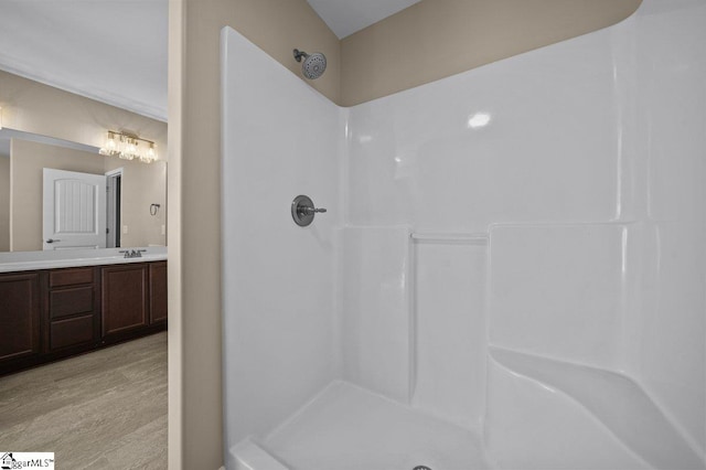 full bath featuring a shower, wood finished floors, and vanity