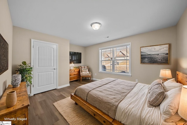 bedroom with dark wood-style flooring, visible vents, and baseboards