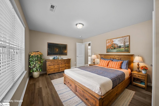 bedroom featuring visible vents, baseboards, and wood finished floors