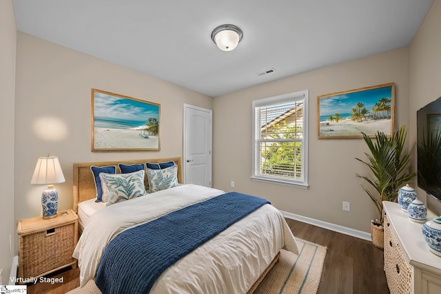 bedroom featuring dark wood-style flooring, visible vents, and baseboards