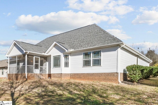 view of front facade with a sunroom, a front yard, and roof with shingles