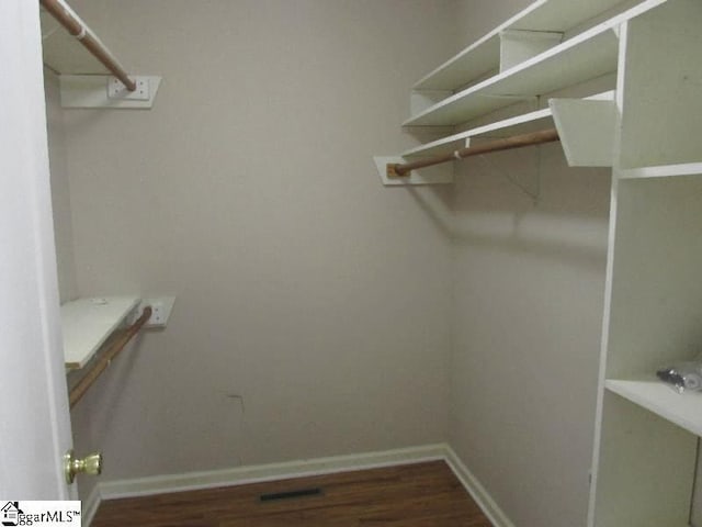 walk in closet with visible vents and wood finished floors