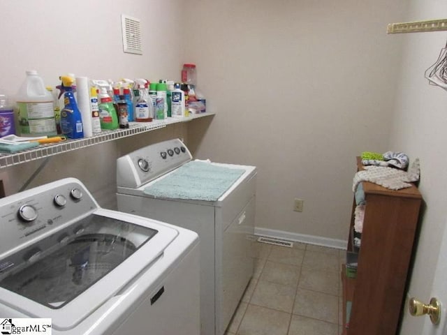 laundry area with laundry area, light tile patterned floors, baseboards, and washer and dryer