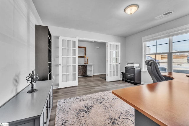 office space with baseboards, visible vents, wood finished floors, and french doors