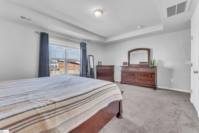 bedroom with carpet floors, baseboards, visible vents, and a raised ceiling