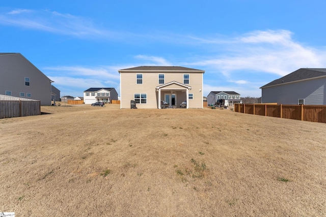 back of house with fence and a yard