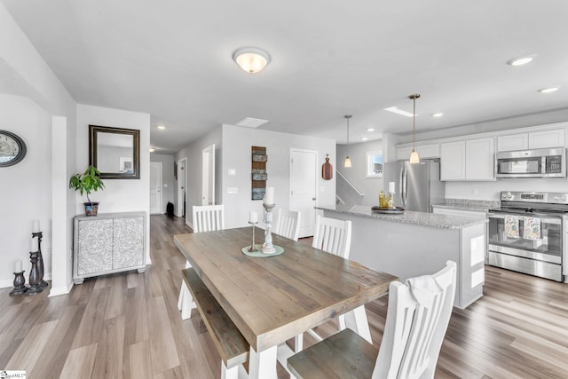 dining space featuring stairway, wood finished floors, and recessed lighting