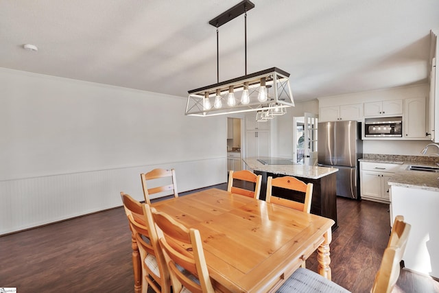 dining space with ornamental molding, dark wood-style flooring, and wainscoting