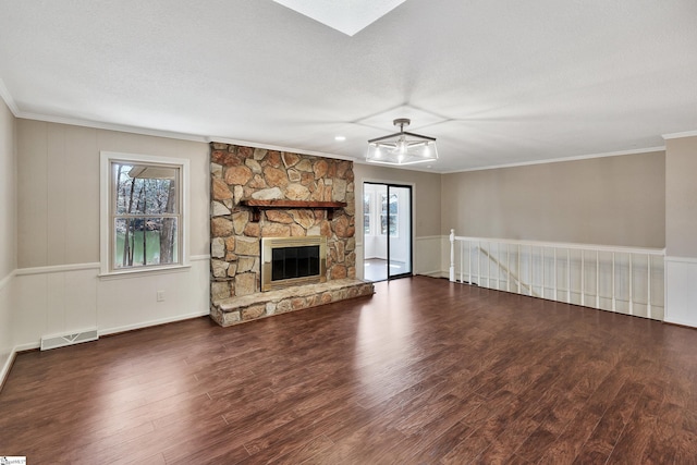 unfurnished living room featuring a fireplace, visible vents, ornamental molding, a textured ceiling, and wood finished floors