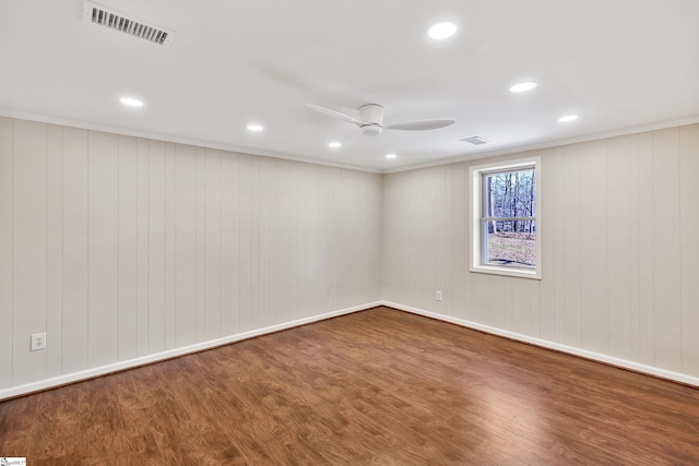 unfurnished room with visible vents, crown molding, and wood finished floors