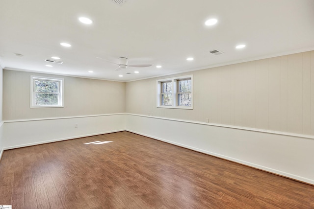 basement with crown molding, visible vents, ceiling fan, and wood finished floors