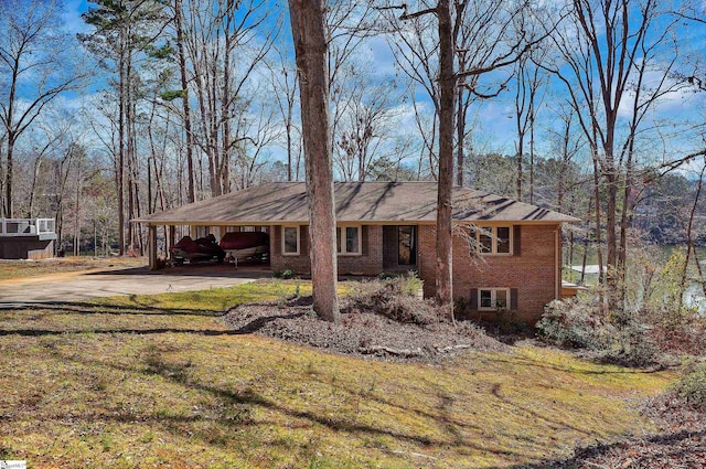 ranch-style house featuring a carport, brick siding, driveway, and a front lawn