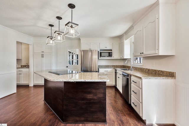 kitchen with dark wood-style floors, appliances with stainless steel finishes, a sink, and white cabinets