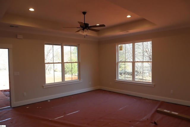 empty room featuring baseboards, a raised ceiling, wood finished floors, and recessed lighting