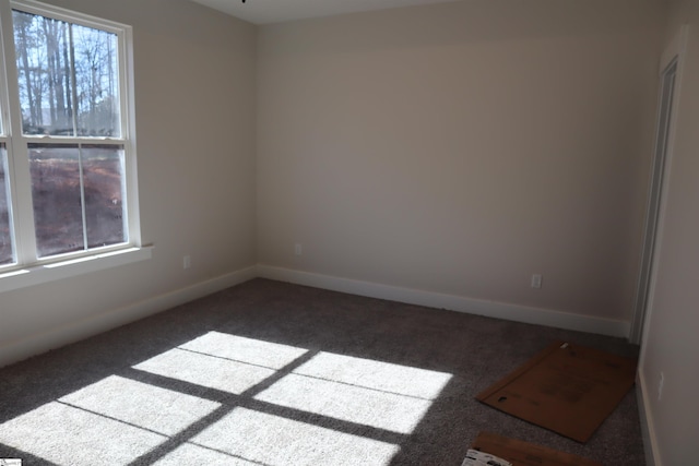 empty room featuring carpet floors and baseboards