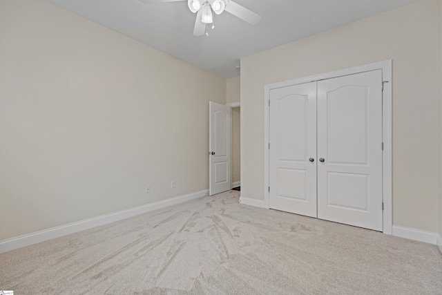 unfurnished bedroom featuring a closet, light colored carpet, and baseboards