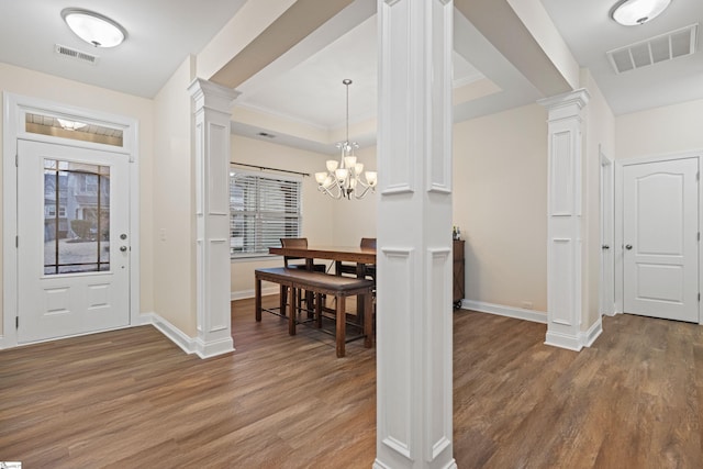 foyer with wood finished floors, visible vents, and ornate columns