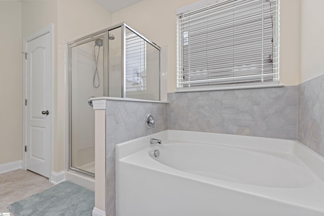 bathroom featuring a garden tub and a shower stall