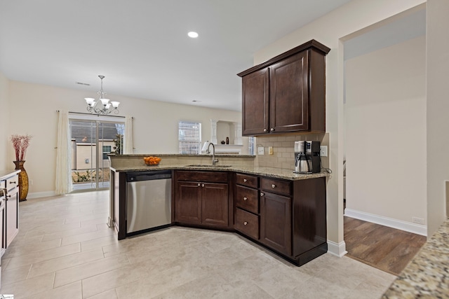 kitchen featuring decorative backsplash, light stone countertops, dark brown cabinets, stainless steel dishwasher, and a sink