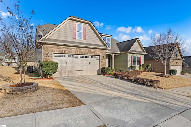 view of front of home featuring a garage, stone siding, driveway, and central air condition unit