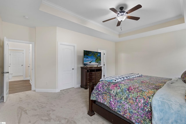 bedroom featuring carpet floors, baseboards, a raised ceiling, and crown molding