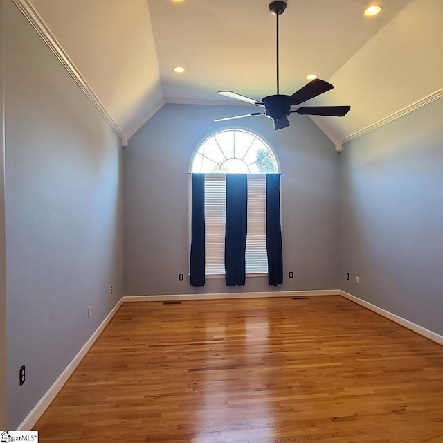 unfurnished room featuring vaulted ceiling, wood finished floors, a ceiling fan, and baseboards