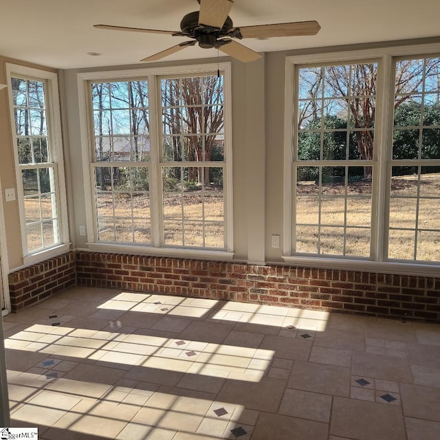 unfurnished sunroom with a ceiling fan