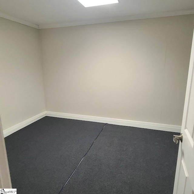 carpeted spare room with crown molding and baseboards