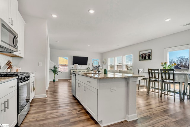 kitchen featuring plenty of natural light, visible vents, stainless steel appliances, and open floor plan