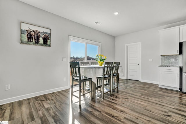 dining room with dark wood-style flooring and baseboards