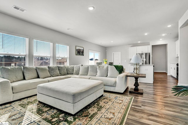 living room featuring baseboards, wood finished floors, visible vents, and recessed lighting