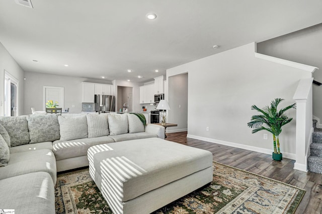 living room with baseboards, stairway, dark wood-style flooring, and recessed lighting