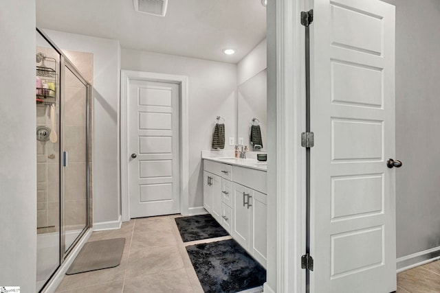 bathroom with a stall shower, vanity, visible vents, and tile patterned floors