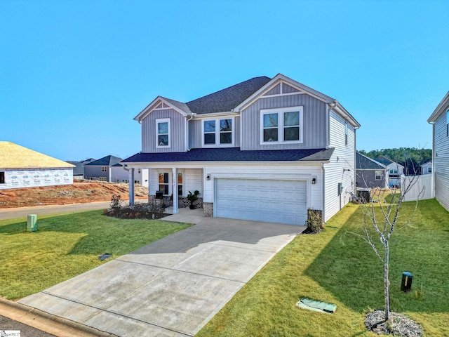 view of front of property featuring an attached garage, fence, driveway, board and batten siding, and a front yard