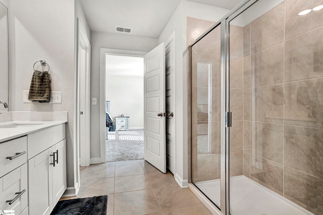 full bath featuring vanity, baseboards, visible vents, a shower stall, and tile patterned floors