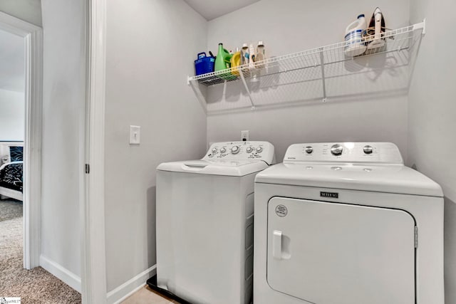 laundry room with light carpet, laundry area, baseboards, and independent washer and dryer