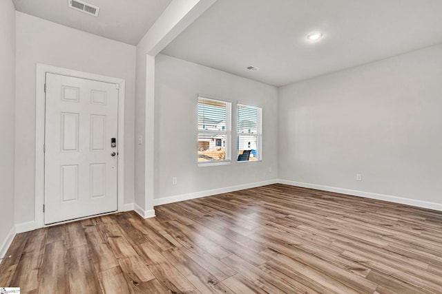 foyer featuring baseboards, visible vents, and wood finished floors