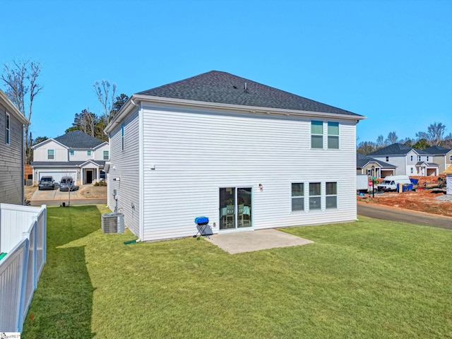 rear view of property with roof with shingles, a yard, a patio area, fence, and cooling unit