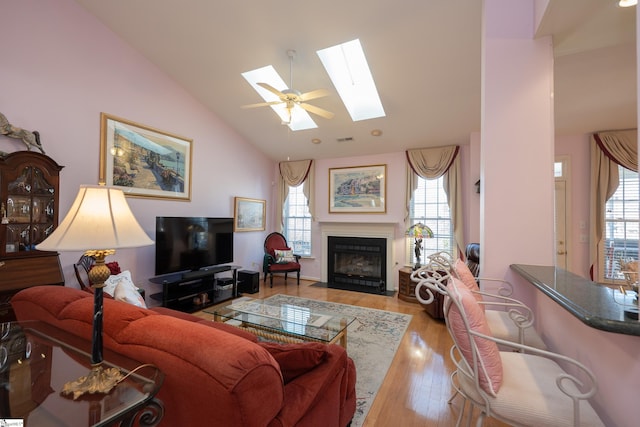 living room with a fireplace with flush hearth, a skylight, and a wealth of natural light