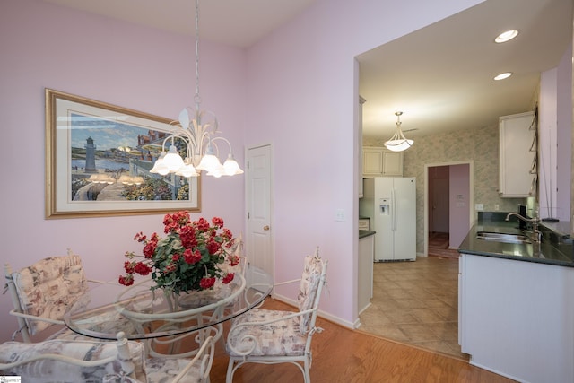 dining area featuring recessed lighting, light wood-style flooring, an inviting chandelier, baseboards, and wallpapered walls