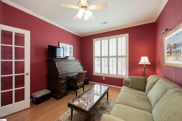 living area with a ceiling fan, visible vents, crown molding, and wood finished floors